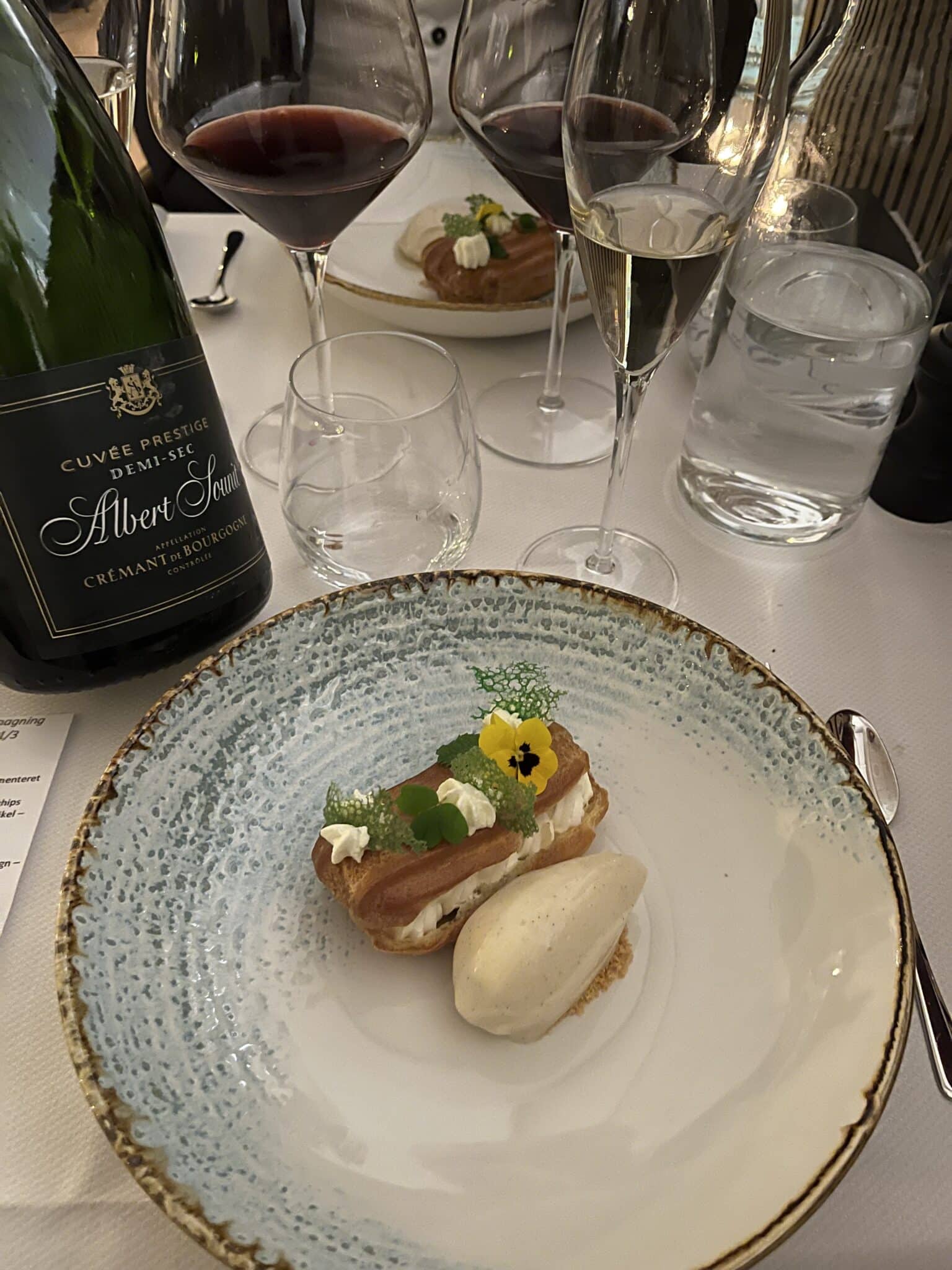 Dessert med is og vin på elegant restaurantbord