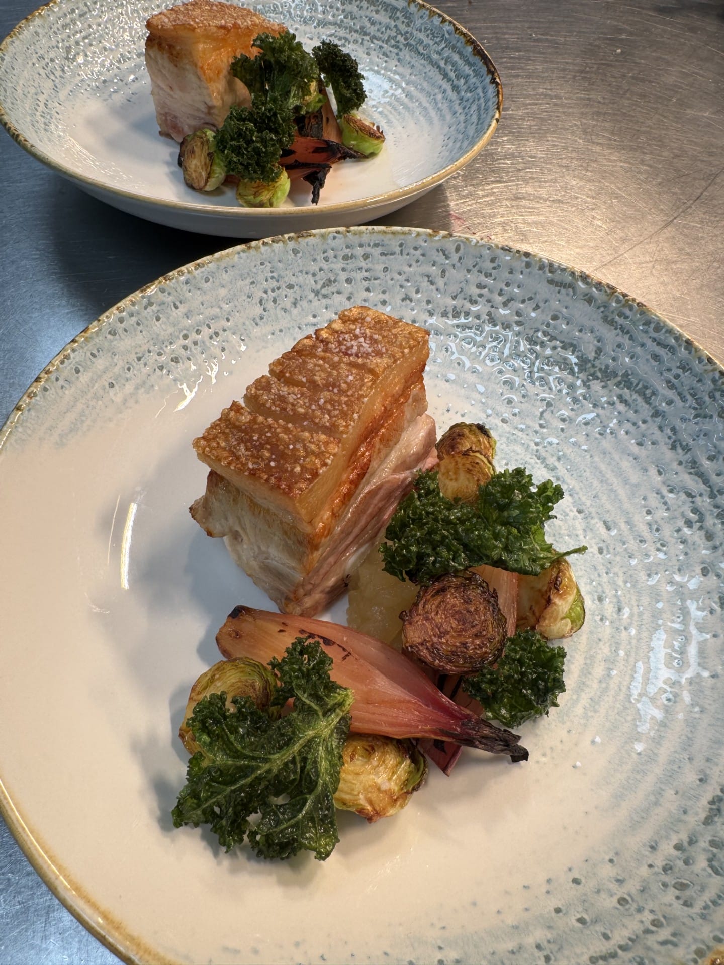 Sprød flæskesteg med grøntsager og kål på tallerken